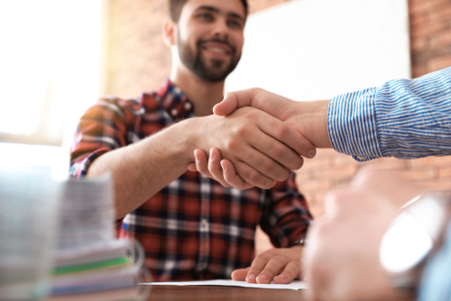 A hiring manager shakes a newly hired employee after getting the recruitment process right