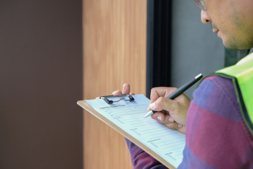 close up of inspector's clipboard while conducting pre-purchase inspection ata building