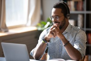 young man behind laptop working on online business