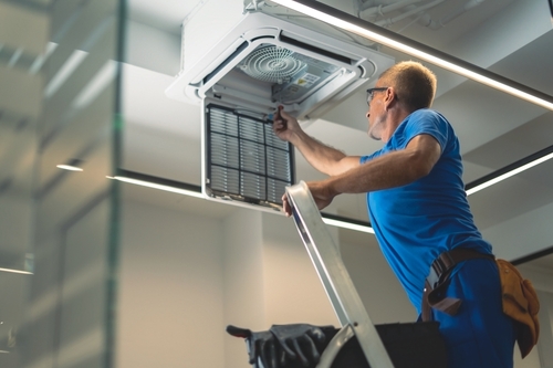 Technical maintenance worker repairs the air conditioning system